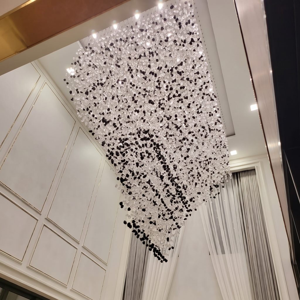 Dense suspended glass elements beneath a rectangular ceiling recess